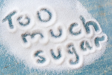 28061554 - the words "too much sugar" written in sugar grains.  overhead view.