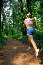 Lady enjoying running on forest trail with more energy